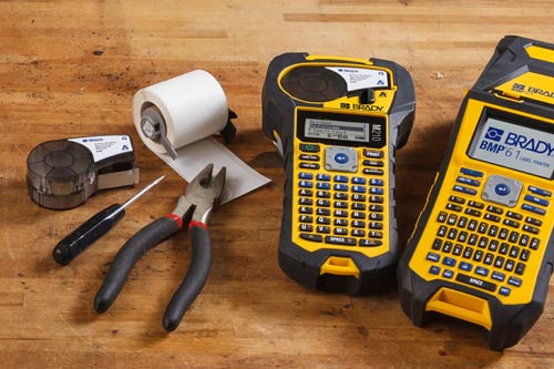 Due cartucce di etichette standard accanto a una stampante per etichette M210 e M610.