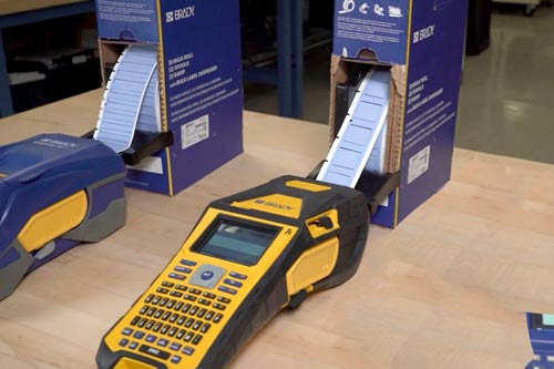 Grande confezione di etichette che vengono alimentate in continuo in una stampante per etichette M610.