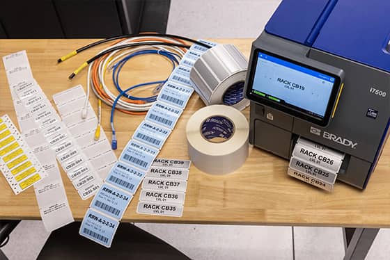 Addetto che applica un’etichetta per cespiti a un computer portatile.