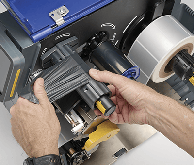 Addetto che carica rapidamente una stampante i7500 con un nuovo nastro.