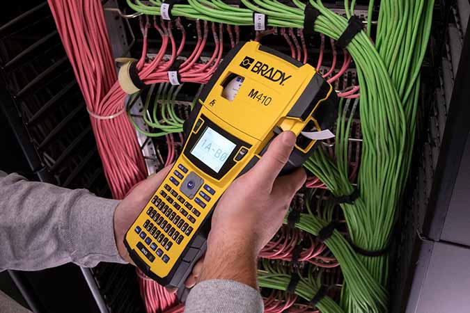 Operatore che utilizza una stampante per etichette M410 per creare etichette destinate alla complessa configurazione di un server. 