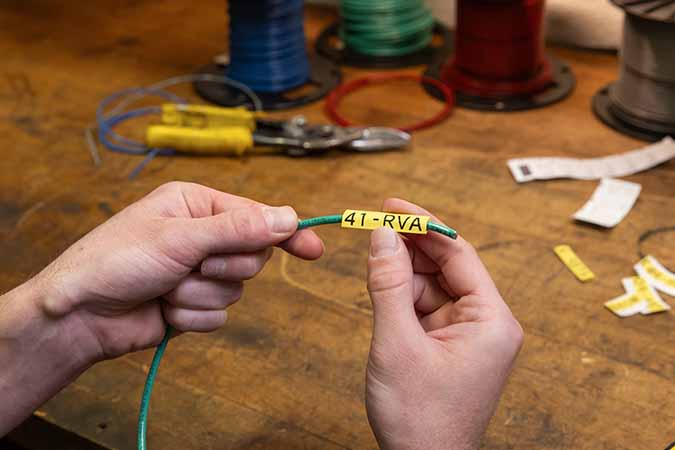 Operatore che avvolge un filo con un’etichetta.