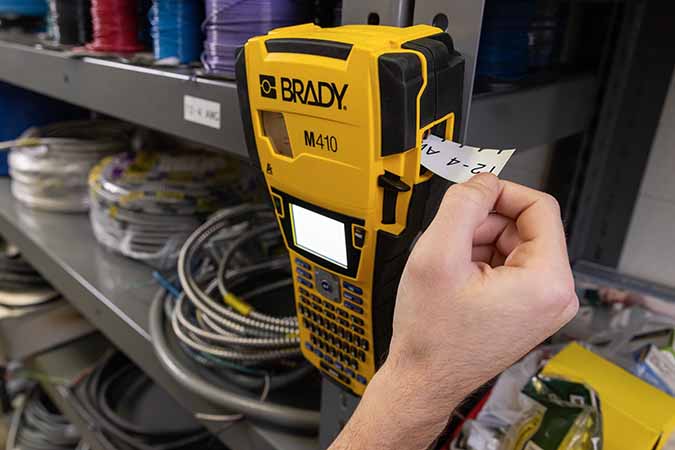 Operatore che utilizza una stampante M410 per stampare un’etichetta da applicare comodamente a uno scaffale con un magnete.