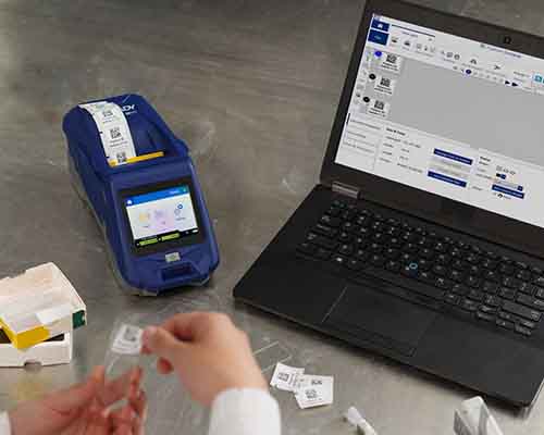 Operatore che applica un’etichetta stampata con la M611 su un vetrino da laboratorio.