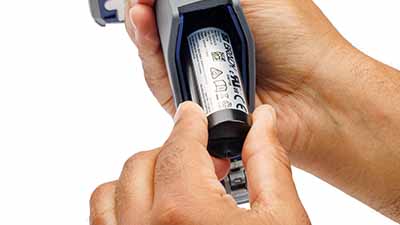 Operatore che inserisce una batteria nell’impugnatura del lettore.
