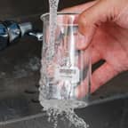 Beuta in vetro con etichetta idrosolubile Brady che viene pulita rimuovendo l’etichetta.