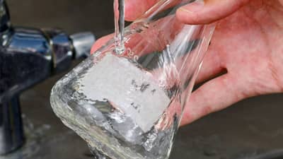 Beuta in vetro con etichetta idrosolubile Brady che viene pulita rimuovendo l’etichetta.