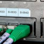 Etichetta Brady applicata su una porta dati di un’apparecchiatura per identificare la funzione della porta.