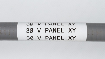 Un’etichetta bianca su un condotto, con testo 