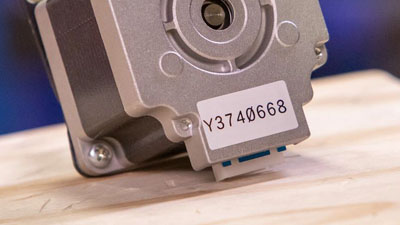 Piccolo componente di un macchinario con un’etichetta in poliestere.