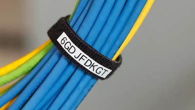 Etichette a strappo BradyGrip avvolte su un gruppo di cavi dati per fissarli e identificarli.