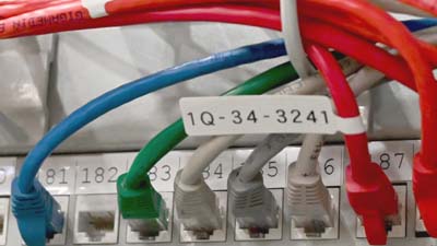 Etichetta a bandiera tipo P Brady in polipropilene opaco applicata su un cavo Ethernet Cat-5e.