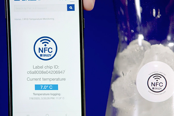 Etichetta RFID visualizzata un’app di un telefono accanto alla corrispondente etichetta fisica applicata su un contenitore criogenico.
